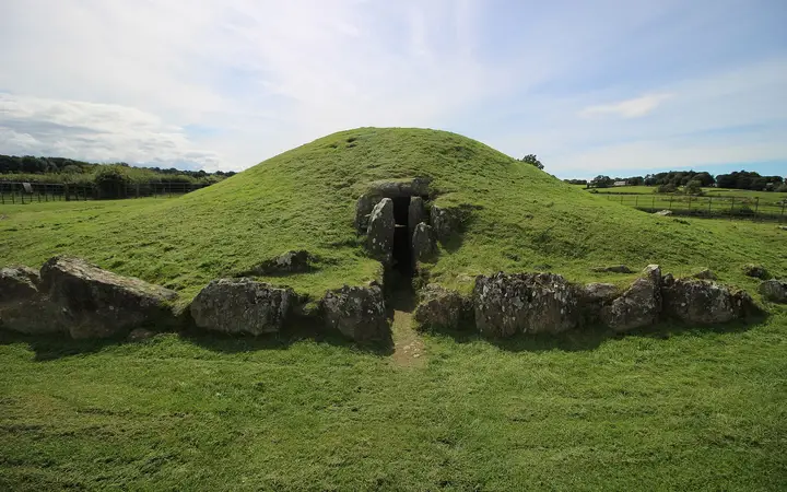 The grassy mound of Bryn Celli Ddu with its stone-lined entrance on Anglesey