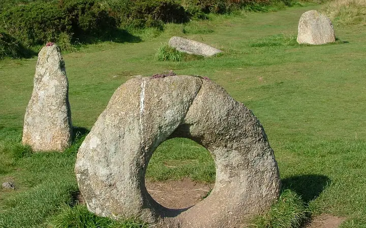 The holed stone of Mên-an-Tol between two upright stones on West Penwith moorland