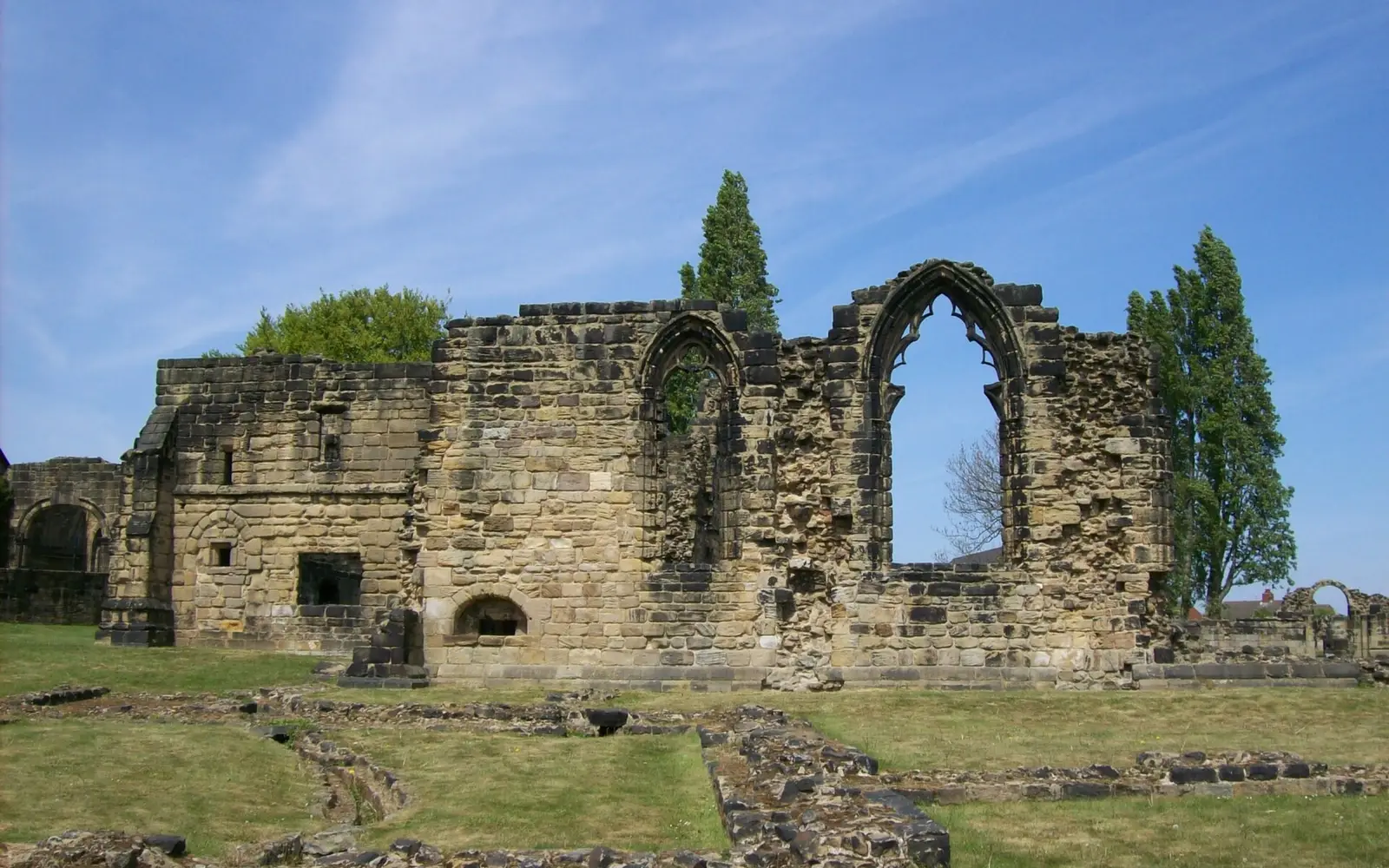 The ruined stone walls of Monk Bretton Priory on a sunny day